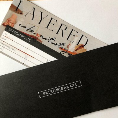 Layered Cake Artistry gift certificate with a black envelope