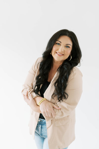 Anna smiling in a beige blazer