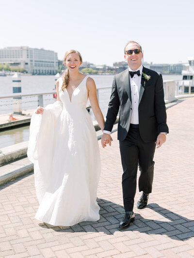 bride and groom walking along the savannah river on the way to reception