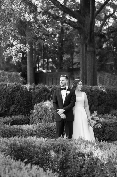 Newlyweds standing close together looking opposite directions