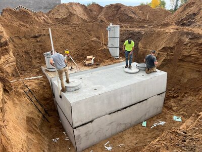 Three men installing a septic system in the ground