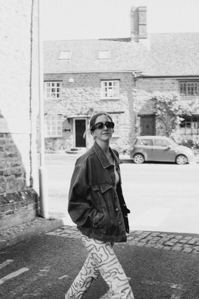 Business coach walks across a street near the Cotswolds