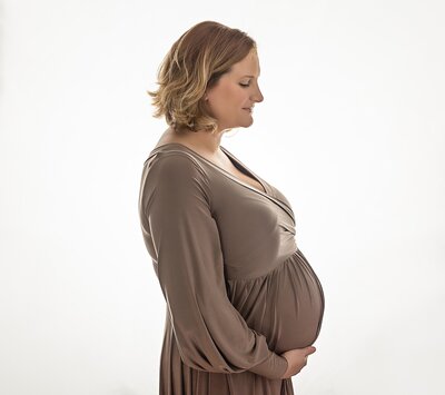 Pregnant mom backlit in taupe gown
