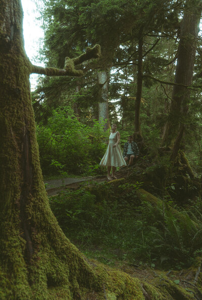 girl spinning in front of man on pnw forest 