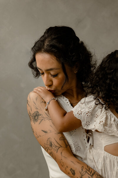 Mom kissing daughter's hand