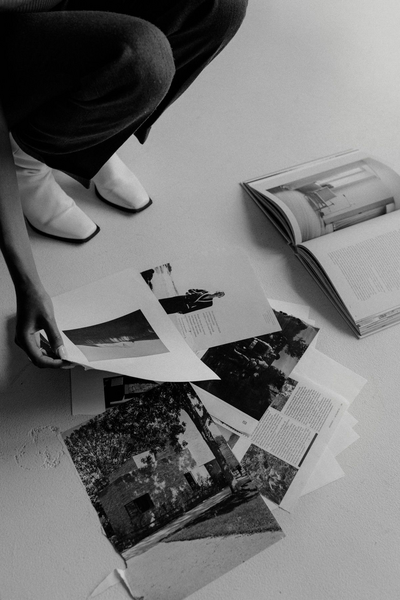 Black and white photo of hands organizing printed pages, representing creative direction and brand strategy development.