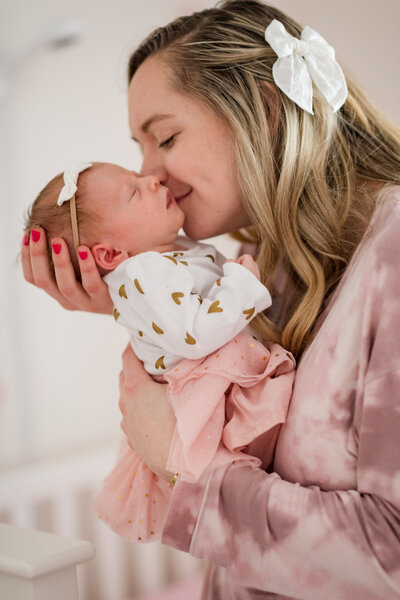 mother kissing newbown baby