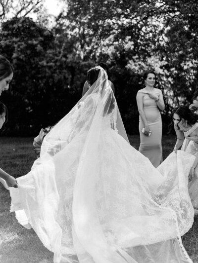 Bride has her veil adjusted by bridesmaids as she gets ready to see her groom.