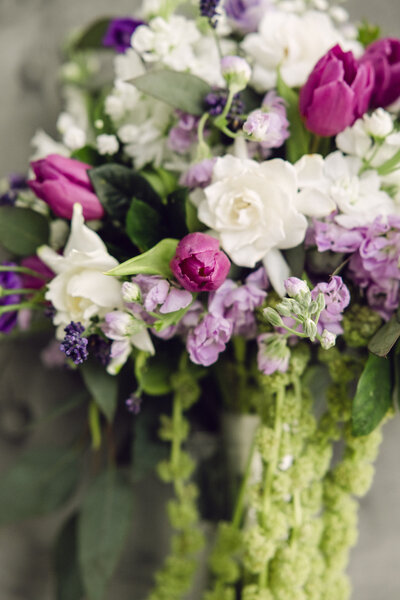 a bride's bouquet of  white, purple, and green flowers