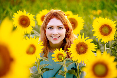 Allie framed by large sunflowers in a sunflower field
