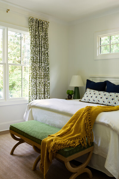 Bedroom suite with green curtains and a yellow throw