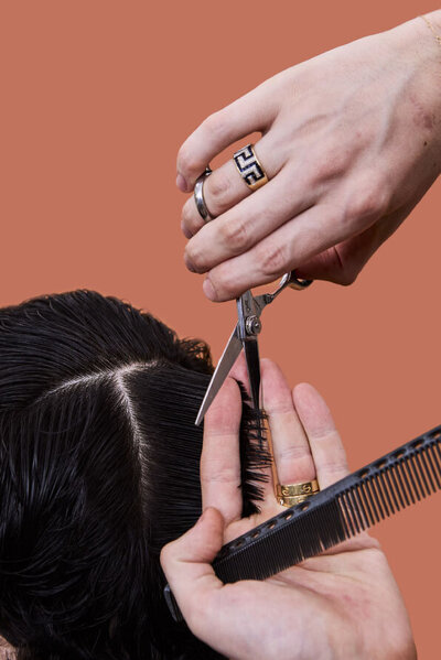 Hairstylist cutting hair with precision scissors in a modern Sydney hair salon.