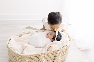 big brother kissing baby sister at main line newborn photography session