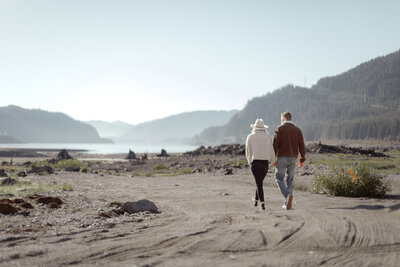 couple holding hands walking on path