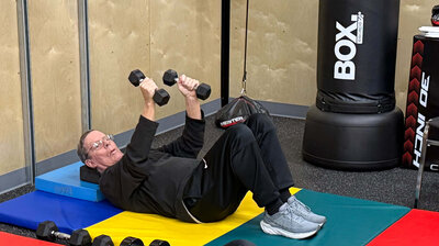 A Parkinson's warrior lifts weights on a mat in the Parkinson's gym in Eugene. 