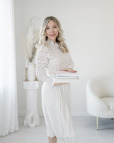 Kristie Lloyd smiles as she holds newborn photo albums