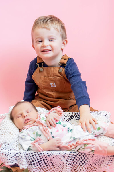 Brother and newborn baby with pink background | Taken by Maine Photographer
