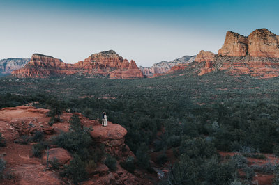 An engaged couple stands on the cliff in Sedona, Arizona. 