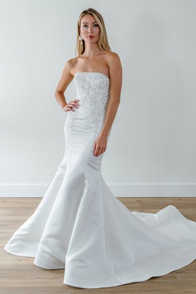 Bride in a strapless fitted gown with lace bodice and flared skirt.