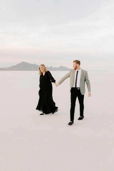 man and woman dressed up and holding hands on the Bonneville Salt Flats in Salt Lake City, Utah