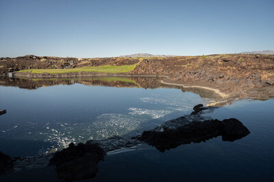 Grand Canyon experience with reflective lake, rocky landscape, and sweeping desert views.
