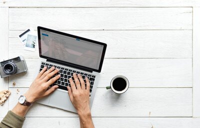 Hands typing on a laptop