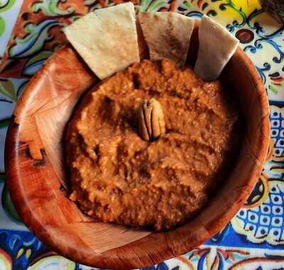 Muhamara is a flavorful Middle Eastern dip made with roasted red peppers, walnuts, garlic, olive oil, and spices, creating a rich and nutty taste.