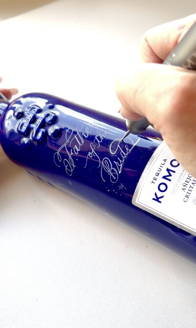 Carla Schall engraving Komos bottles for Father's Day brand activation events across the country:Miami. Chicago,New York, Dallas,Los Angeles