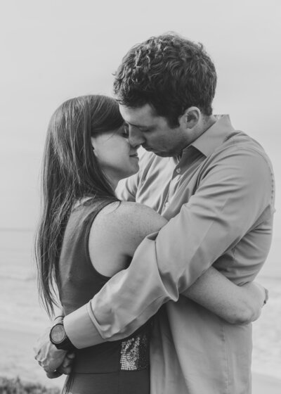 A couple with their arms around each other about to kiss 