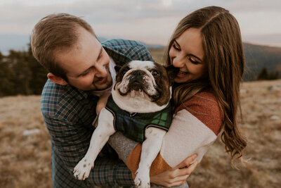 couple laughing with puppy