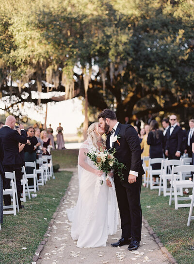 Newlywed kiss moment during a garden wedding ceremony in Charleston