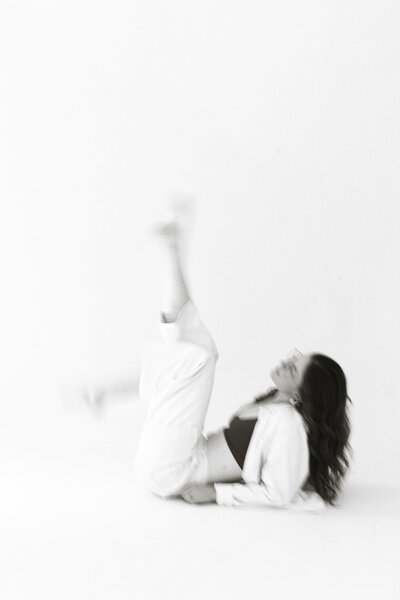 blurry black and white of woman on ground kicking legs