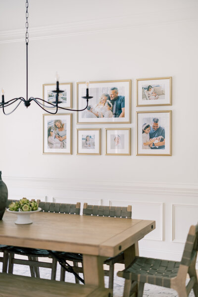 Custom gallery wall installation in dining room featuring framed family portraits – Charlotte family photographer