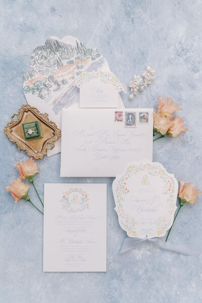 Wedding invitation suite with soft pastel florals, rings, and decorative elements, captured by a Virginia wedding photographer.