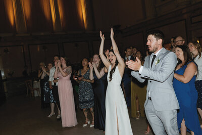 Wedding guests laughing and enjoying the reception, captured in a candid and authentic moment.