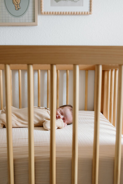 In-Home newborn session with baby laying and sleeping in crib