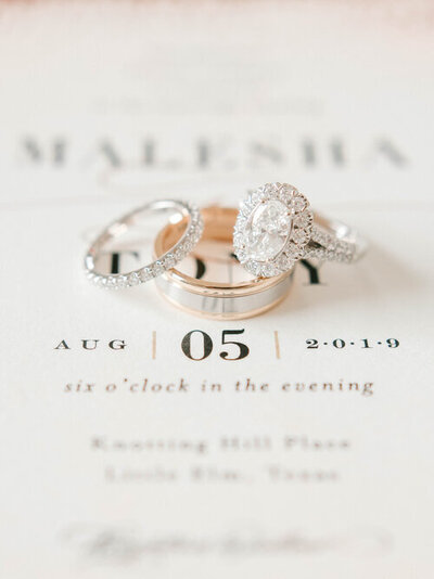 Bride and Groom's wedding rings on top of invitation