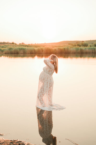 zwangere vrouw in water tijdens het golden hour