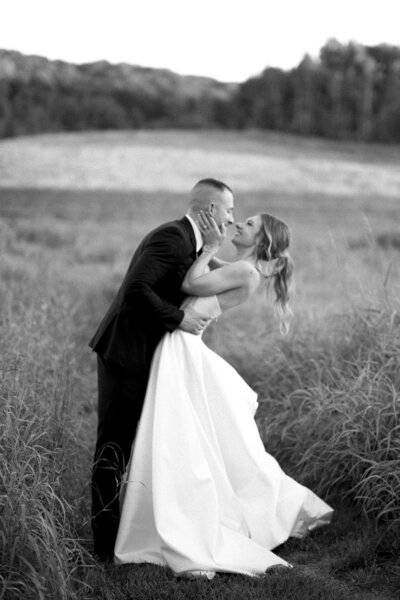 bride and groom in field at sunset