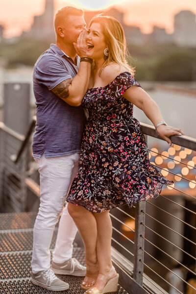 Engaged couple in Atlanta, with the guy making the woman laugh, sharing a joyful and carefree moment in warm golden-hour light.