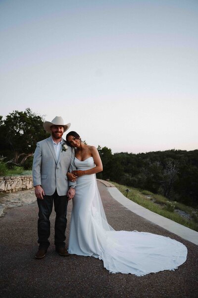 Bride and groom poses on side walk leading up to Chapel Dulcinea