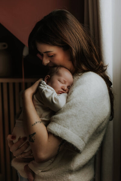 Mama omhelst baby tijdens newbornshoot