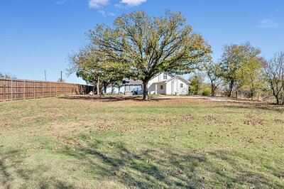 Large open yard for the kids to play at this four-bedroom, three-bathroom vacation rental home with game room, spa, and firepit located on the edge of Waco, TX.