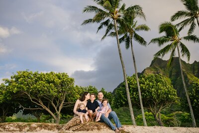 A family with three children sit on the beach of Kailua.