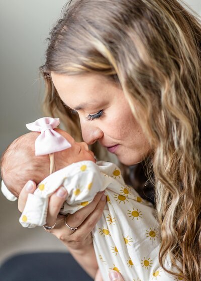 mom touching noses with newborn during in home newborn session