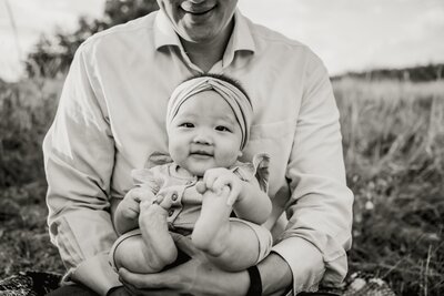 baby in her dad's arms at a family session in plano, texas
