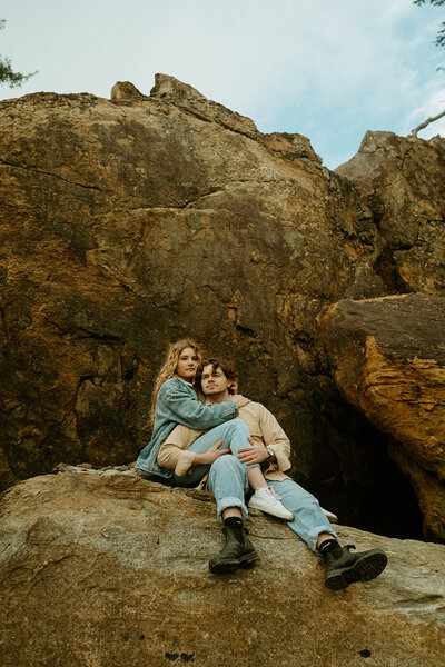 couple sitting on a rock holding each other