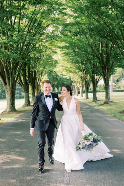 Bride nd groom walking arm in arm and laughing