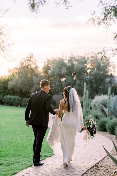 Bride and Groom Walking down path during sunset
