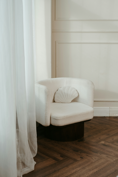 white boucle chair next to window in home